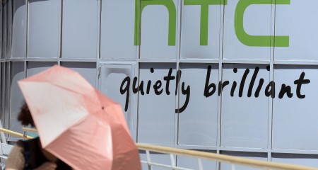 A woman walks past the logo for Taiwan's